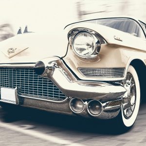 A Classic Cadillac Captured In Motion, Showcasing Its Vintage Charm And Sleek Design.