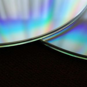 Detailed Close Up Of Two Overlapping Compact Discs Showing A Colorful Rainbow Reflection.