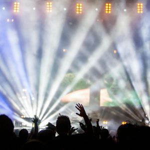 Vibrant Nightclub Concert With Cheering Crowd And Dazzling Spotlights.