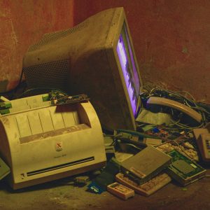 Old Electronics Pile With A Vintage Computer And Printer In A Basement Setting.
