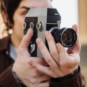 A Person Filming With A Vintage Analog Camera, Capturing A Creative Moment.