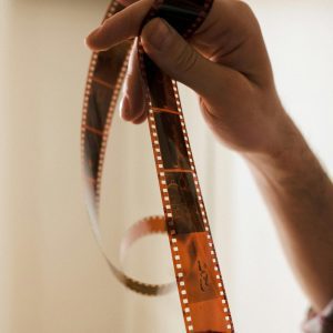 Detailed Close Up Of Hands Gently Handling A Film Strip With Selective Focus.