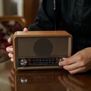 Person Adjusting Vintage Wooden Radio Knob, Close Up Indoor Shot.