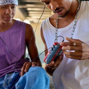 Two Teenagers Sharing Music Using A Retro Walkman, Showcasing Friendship And Nostalgia.