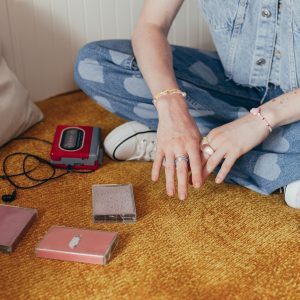 A Person In Denim With Cassette Tapes And A Walkman, Evoking 90s Nostalgia.