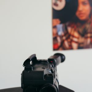 A Vintage Video Camera On A TV Set With A Retro Style Poster Blurred In The Background.
