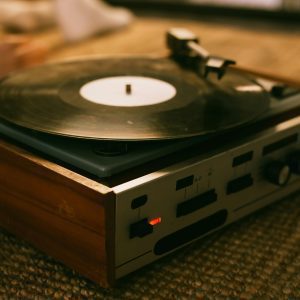 Close Up Of A Vintage Vinyl Record Player On A Textured Rug, Highlighting Analog Music Ambiance.