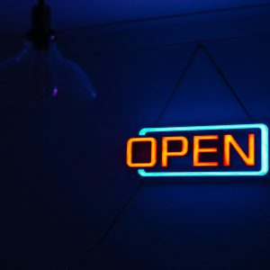 Brightly Lit 'Open' Neon Sign Against A Dark Background, Creating A Vibrant And Inviting Atmosphere.