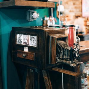 A Classic Vintage Camera Exhibited In A Cozy Retro Café Setting, Capturing Nostalgia.