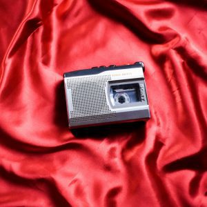 Classic Vintage Cassette Player On Luxurious Red Satin Fabric, Highlighting Nostalgic Technology And Style.