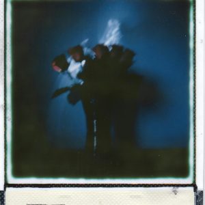 A Moody, Blue Toned Polaroid Capturing A Blurred Bouquet Of Flowers In A Vase, Creating A Vintage Aesthetic.
