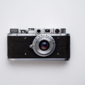 Classic Vintage Film Camera Captured In A Minimalist Flat Lay Style On A White Background.