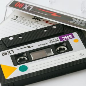 Close Up Of A Vintage Cassette Tape With A Plastic Case On A White Background.