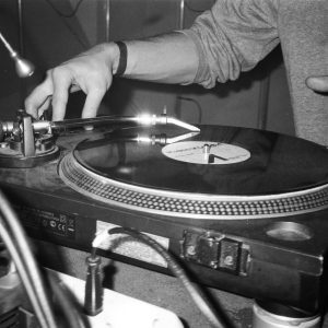 Close Up Of A DJ Using A Turntable To Play Vinyl Records, Showcasing Music Equipment.