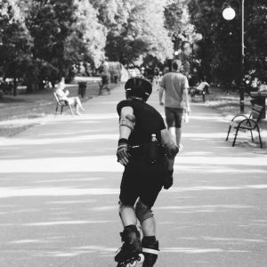 Black And White Photo Of A Person Rollerblading On A Park Path, Captured In Motion.