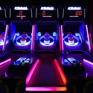 Vibrant And Illuminated Ski Ball Machines In A Dark Arcade Setting.