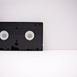 Black VHS Tape On A White Minimalist Background, Highlighting Retro Technology.