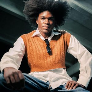 Portrait Of A Model With Afro Hair In A Vintage Outfit, Exuding Confidence And Style.