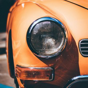 Detailed Close Up Of A Classic Orange Car Headlight Reflecting Sunlight, Captured In Barcelona.