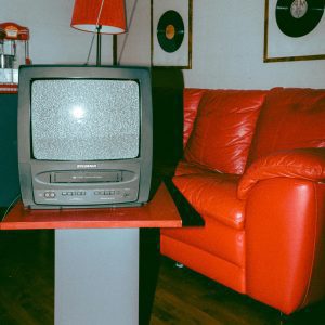 Vintage Themed Room With A Classic TV, Red Couch, And Vinyl Records.