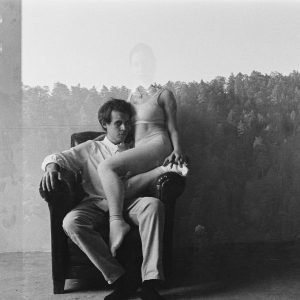 Artistic Double Exposure Of A Couple In An Indoor Setting With A Forest Overlay.