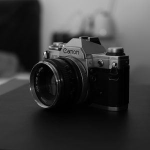 A Vintage Canon Film Camera Captured In An Artistic Black And White Style, Emphasizing Its Classic Design.