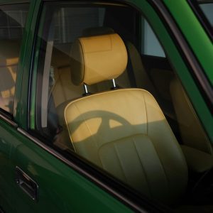 A Retro Car Interior Featuring Yellow Leather Seats And Sunlight Shadows, Captured In Tokyo.