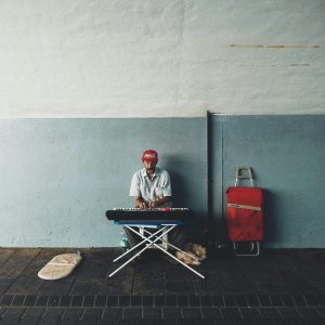 A Street Musician Plays A Keyboard Under A Bridge, Showcasing Urban Art And Culture.