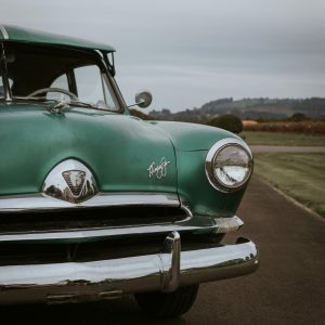 A Classic Green Henry J Corsair Parked On A Scenic Road In Oregon.