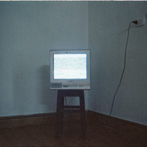A Vintage CRT Television Displaying Static Noise In A Minimalist Room Setting.
