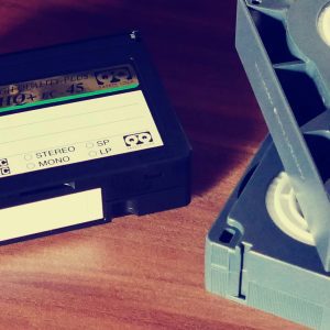 Close Up Of Vintage VHS Tapes On A Wooden Table, Highlighting Old Technology And Nostalgia.