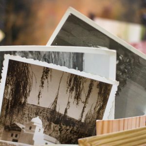 Close Up Of A Stack Of Vintage Photographs Displaying Historic Scenes.