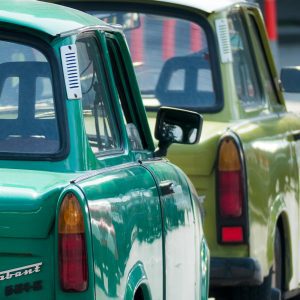 Close Up Of Retro Trabant Cars In Green Color Parked On A Sunny Urban Street.