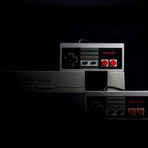 Retro Gaming Controllers From The Nintendo Entertainment System In Low Key Lighting, Evoking Nostalgia.