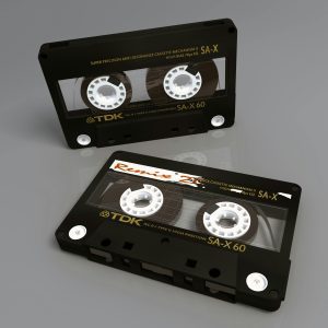 Two Vintage TDK SA X 60 Cassette Tapes Showcasing Retro Audio Technology On A Reflective Surface.