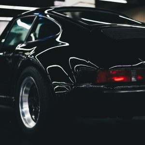 Elegant Classic Black Car With Shiny Chrome And Rear Lamp Visible In An Indoor Setting.