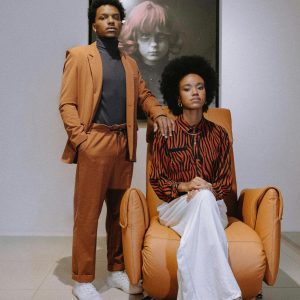 Elegant Portrait Of A Fashionable Couple Posing In A Modern Setting With Retro Vibes.