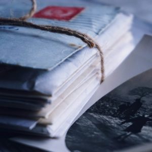 A Close Up Of Vintage Letters Tied With Twine Alongside An Old Black And White Photograph.