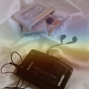 A Classic Walkman With Cassettes And Earphones, Evoking Nostalgia.