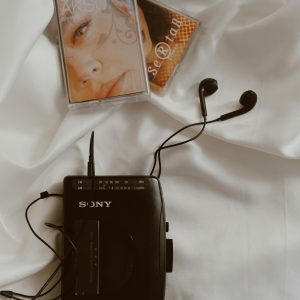 Vintage Walkman With Cassette Tapes On A Silky Fabric, Evoking Nostalgia.