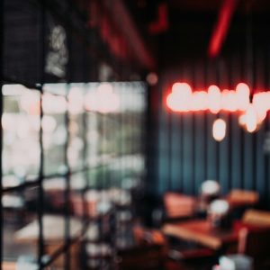 Cozy Restaurant Interior Featuring Modern Furniture, Blurred Neon Lights, And Window Views.