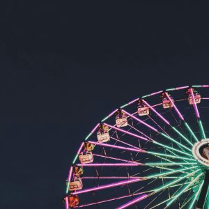 Colorful Ferris Wheel Glowing In The Night Sky, Capturing Amusement Park Vibes.