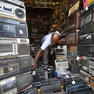 Man In Kolkata Shop Filled With Vintage Radios And Electronics. Nostalgic Atmosphere.