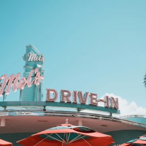 A Vintage Drive In Diner Featuring Classic Neon Signage And Vibrant Red Umbrellas.