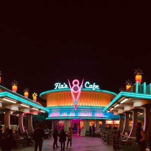 Vibrant Neon Lights Illuminate Flo's V8 Cafe As Visitors Explore The Lively Nighttime Atmosphere.