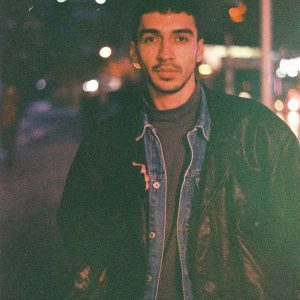 Stylish Man In Malatya City Street At Night, Showcasing Urban Fashion With Leather And Denim.