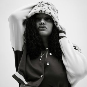 Stylish Black And White Portrait Of A Woman In Fashionable Attire With A Confident Pose.