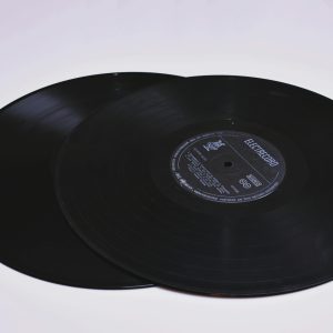 Close Up Of Two Classic Vinyl Records On A Flat Surface, Showcasing Grooves.