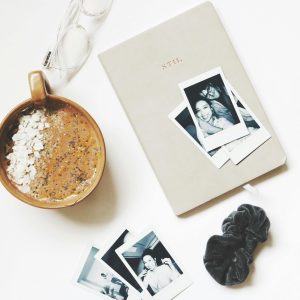 A Cozy Flat Lay Featuring Coffee, A Journal, Eyeglasses, And Polaroid Photos.