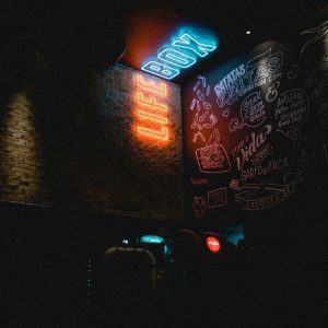 Neon 'LIFE BOX' Sign Glowing In A Dimly Lit Urban Environment With Graffiti Art.